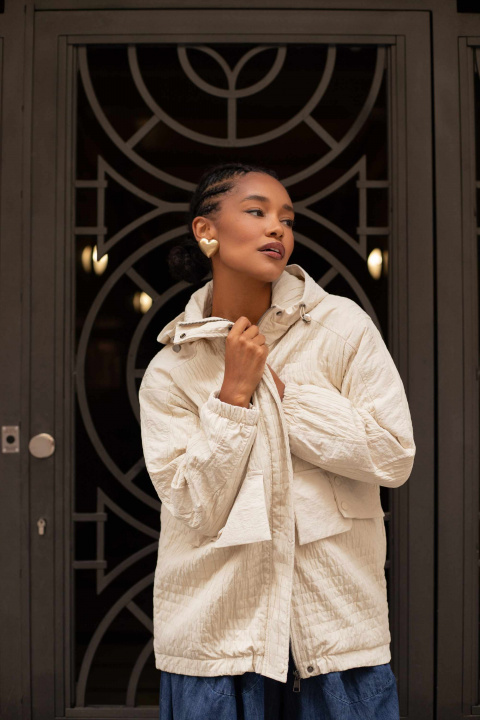 Дамско капитонирано яке с качулка в светлобежово и джобове с капаци